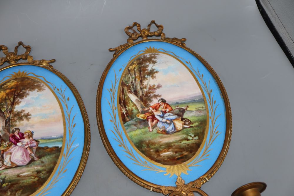 A pair of gilt brass two branch wall sconces with oval Sevres style plaques, length 40cm